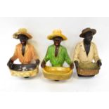 Three figural busts of men holding baskets in front of them, each on base, height of largest 41cm.