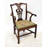 A George III mahogany elbow chair with pierced vase-shaped splat back, drop-in needlework seat and