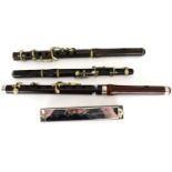 Three early 20th century piccolos comprising a Boosey & Co example, length 28cm, in a black