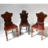 Two matching Victorian mahogany shield back hall chairs and a similar example (one af) (3).Condition