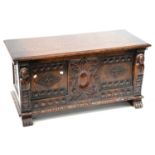 A mid-20th century carved oak coffer with Medieval-style carved panels to the front with bust of a