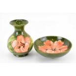 MOORCROFT; a Hibiscus pattern short vase, height 13.5cm, and bowl, both with green ground, with