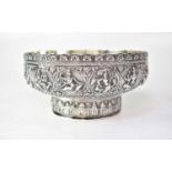 An Indian silver bowl decorated with roundels of deities within floral and scroll surrounds, the