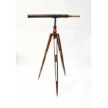 A late 19th/early 20th century brass two-drawer telescope with leather-covered body, mounted on an