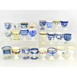 Twenty-four assorted late 19th/early 20th century egg cups, mostly blue and white and floral