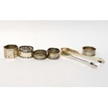 A pair of Georgian hallmarked silver sugar tongs, four assorted napkin rings and an oval salt,