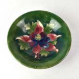 MOORCROFT; an Anemone pattern bowl on green ground, impressed marks and blue signature to base,
