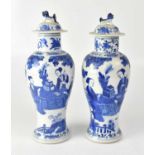 A pair of Chinese blue and white baluster form lidded vases, with Dogs of Fo knops to lids,