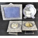 Four hallmarked silver photograph frames comprising a pair of small square examples with circular