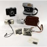 A small collection of cameras comprised of an Olympus mju-II Zoom 80 Panorama, a Polaroid P600, a
