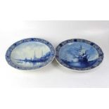 DELFT; a pair of blue and white chargers, each with central panel decorated with boats, and