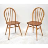 ERCOL; four light elm stick back dining chairs with arched backs (4).