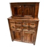 A reproduction carved oak court cupboard, the upper section with a pair of frieze cupboard