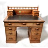 An early 20th century oak kneehole desk with galleried back rail, with two banks of small drawers
