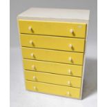 A mid-20th century chest of six long drawers painted in cream and yellow, with white plastic