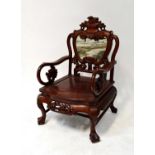 A Chinese carved hardwood open armchair, the shield-shaped back inset with a hard stone panel