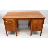 A mid-20th century oak desk comprising two pedestals with slides and configuration of drawers, on