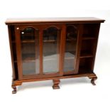 A mid-20th century mahogany glazed bookcase with twin panelled arched glazed sliding doors, on