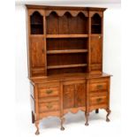 A George III style oak dresser with enclosed plate rack above an inverted break-fronted base of four