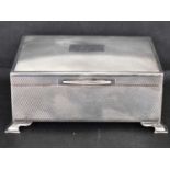 A George VI hallmarked silver desk top cigarette box with engine turned decoration, blank panel to