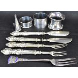Various items of hallmarked silver to include three non-matching napkin rings, a candle snuffer, two