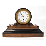A mahogany and ebonised mantel clock, the white enamelled dial set with Roman numerals and verge