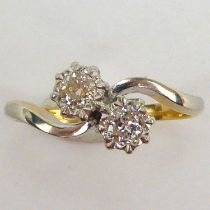 An 18ct gold diamond crossover ring, with two claw set brilliants, each approx. 1.5ct, with white