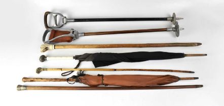 A small collection of vintage walking sticks including a silver-topped example, a further example