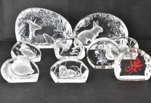 Nine modern moulded glass paperweights with scenes depicting animals in natural settings,