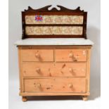 An early 20th century pine chest of two short over two long drawers, raised on bun feet with