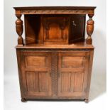 A reproduction oak court cupboard, with single arched door above a pair of panelled doors, raised on