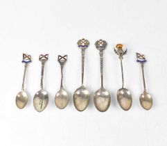 Seven silver commemorative spoons for the Royal Mail shipping line, six with enamelled finials and