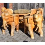 A large modern carved hardwood elephant circular table and chair set, the table with carved elephant