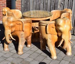 A large modern carved hardwood elephant circular table and chair set, the table with carved elephant