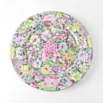 A Chinese polychrome decorated plate with various flowers within printed black borders, four-