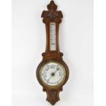 An early 20th century oak cased barometer of banjo form, the white glass face inscribed 'Storm -