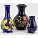 MOORCROFT; three items of blue ground pottery, comprising a globe and shaft shaped 'Hibiscus'