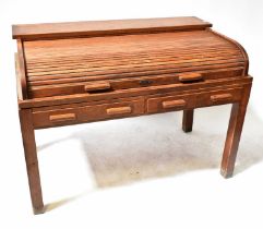 A c.1930s oak office desk with tambour roll-back top and interior pigeonholes, above two single