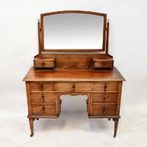 An Edwardian mahogany kneehole dressing chest, the arched bevelled plate above a pair of short