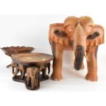 A carved wooden stool in the form of an elephant, height 40cm, diameter 32cm, and two table bowls on