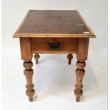 An early 20th century pine table with inset canvas top, raised on substantial turned supports with