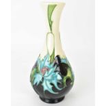 MOORCROFT; a 'Thistle' pattern vase of bottle form, by Eric Cals, depicting blue leaf thistles on an