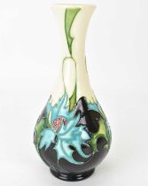 MOORCROFT; a 'Thistle' pattern vase of bottle form, by Eric Cals, depicting blue leaf thistles on an