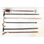 A small collection of walking sticks, including two examples with novelty tops, one in the form of a