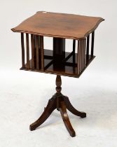 An early 20th century mahogany revolving bookcase, the moulded shaped top above slatted storage,