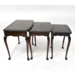 A contemporary mahogany nest of three tables, raised on slender Queen Anne supports to pad feet.