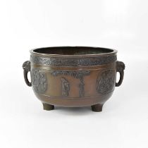 A large Chinese bronze twin-handled jardinière, raised on three feet, the handles in the form of