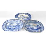 Three blue and white meat plates and two circular blue and white chargers, including a tin glazed
