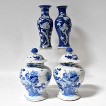 A pair of late 19th century Chinese blue and white baluster vases and covers, both with painted