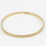 A 9ct gold bangle with engine turned decoration, internal diameter approx. 7.8cm, approx. 14.8g.